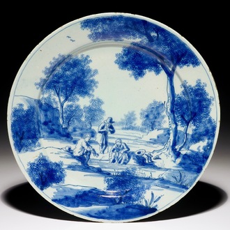 A fine Dutch Delft blue and white plate with men near a river, early 18th C.
