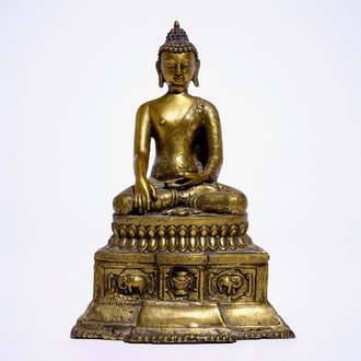 Un modèle d'un Bouddha assis sur un trone en bronze doré, Nepal ou Tibet, 19/20ème