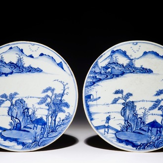 Une paire de plaques rondes aux paysages en porcelaine de Chine bleu et blanc, Kangxi