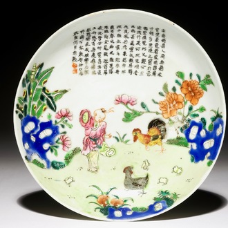 Une assiette en porcelaine de Chine famille rose à décor d'un garçon avec deux poules, marque de Jiaqing, 19ème