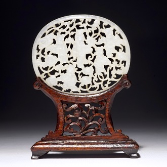 A Chinese reticulated jade plaque, on wooden stand, 19th C.