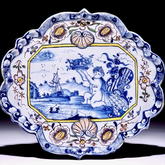A polychrome Dutch Delft plaque with a putto holding a fruit basket, 18th C.