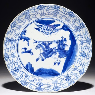 Een blauw-wit Chinees gecontourneerd bord met een jachtscène, Kangxi