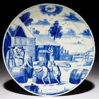 A Dutch Delft blue and white plate with barrel makers from the 'Zodiac' series, early 18th C.