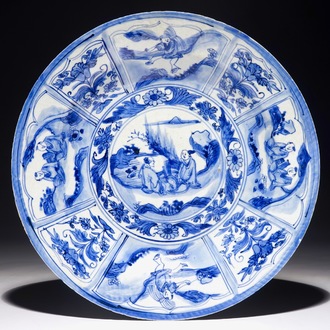 Un plat en porcelaine de Chine bleu et blanc à décor de figures dans un paysage, époque Transition
