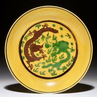 Une assiette en porcelaine de Chine à décor de dragons sur fond jaune, Kangxi