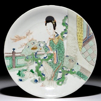 Un plat en porcelaine de Chine famille verte figurant une dame dans un jardin, marque et époque de Kangxi