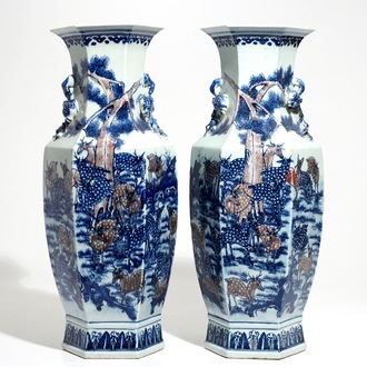Une paire de vases en porcelaine de Chine à décor de cerfs et lions bouddhistes en rouge et bleu, 19ème