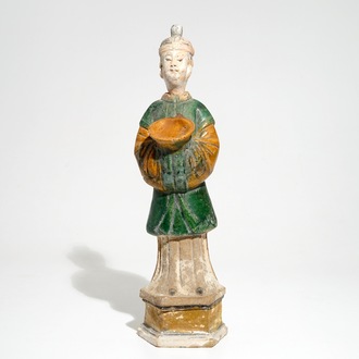 Een Chinese sancai figuur van een dienaar op sokkel, Ming