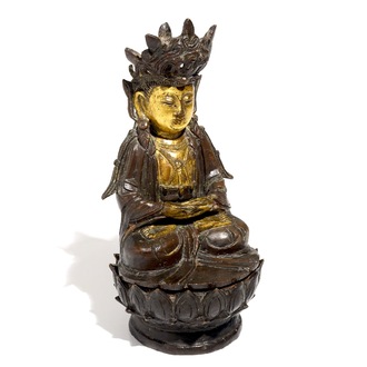 A partly gilt Chinese bronze figure of Buddha seated on a lotus throne, late Ming