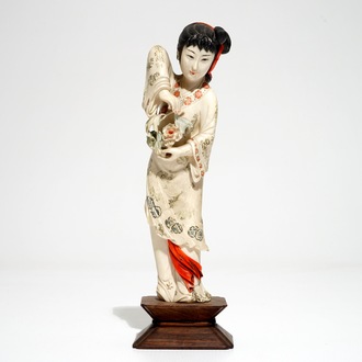 Een Chinese polychrome ivoren figuur op houten sokkel, 2e kwart 20e eeuw