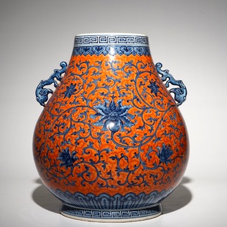 Un vase de forme hu en porcelaine de Chine aux rinceaux de pivoines sur fond rouge corail, marque de Yongzheng, 20ème