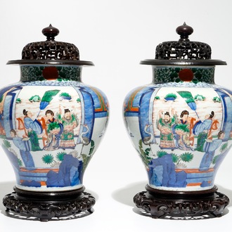 A pair of Chinese wucai baluster vases with carved lids and bases, 19th C.