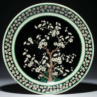 A Chinese famille noire biscuit prunus tree charger, Kangxi