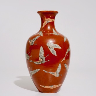 Un vase en porcelaine de Chine aux papillons sur fond corail, marque de Qianlong, 19/20ème