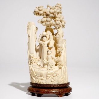 A Chinese ivory group on wooden stand, 2nd quarter 20th C.