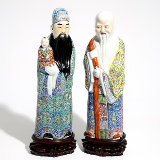 Une paire de figures d'immortels en porcelaine de Chine famille rose sur socles en bois, 19/20ème