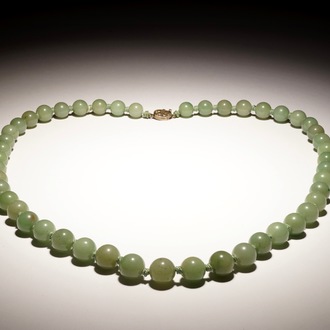 A Chinese green jade beads necklace with silver lock, 19/20th C.