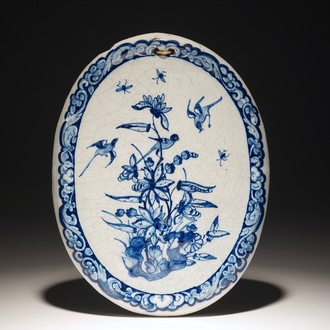 An oval Dutch Delft blue and white plaque with birds among flowers, 18th C.