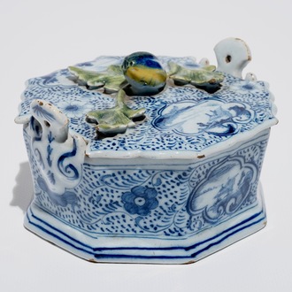 A Dutch Delft blue and white butter tub with polychrome finial, 18th C.