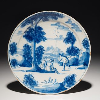 A Dutch Delft blue and white plate with figures in a landscape, 1st half 18th C.