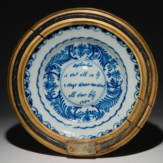 Un plat à ombilic en faïence de Delft bleu et blanc encadré, daté 1787