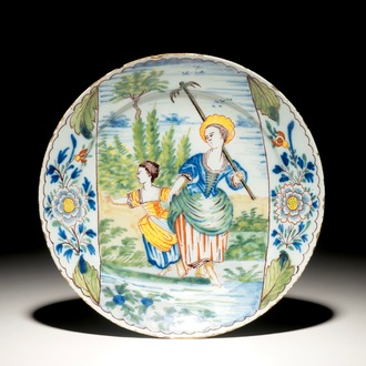 A polychrome Dutch Delft plate with a gardening lady and her daughter, 18th C.