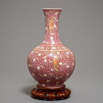 Un vase de forme bouteille en porcelaine de Chine famille rose sur fond rouge rubis, marque de Qianlong, 19/20ème