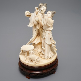 A Chinese carved ivory group of two ladies near an altar table, 1st half 20th C.