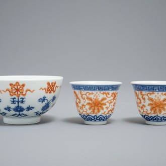 A pair of Chinese iron red and blue cups and a bowl, Qianlong and Guangxu marks, 19/20th C.