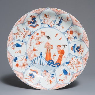 Un grand plat en porcelaine de Chine de style Imari à décor de femmes dans un jardin, Kangxi/Yongzheng