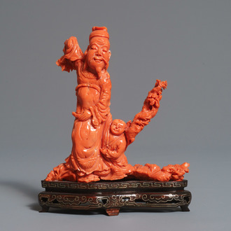 A Chinese carved red coral figure of a sage with a child, 19/20th C.