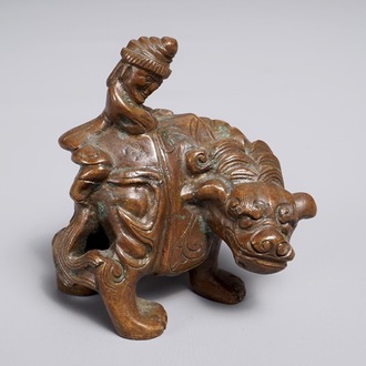 Een Chinees bronzen scroll- of papiergewicht in de vorm van een fabeldier met berijder, 19/20e eeuw