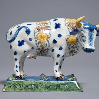 A polychrome Dutch Delft cow on a base with frogs, 18th C.