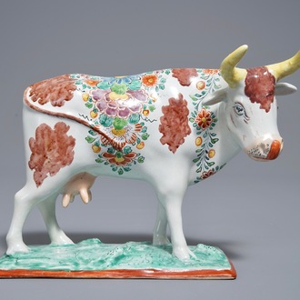 A polychrome Dutch Delft petit feu cow on base, 18th C.
