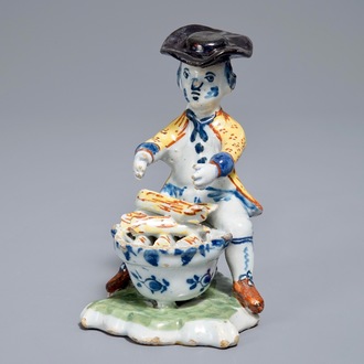 A polychrome Dutch Delft model of a man near a stove, 18th C.