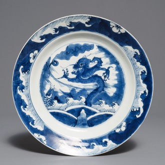 Un plat en porcelaine de Chine bleu et blanc à décor d'un dragon et une carpe, Kangxi