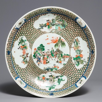 A massive Chinese famille verte dish with figures in a landscape, 19th C.