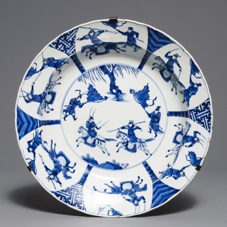 Un plat en porcelaine de Chine bleu et blanc à décor d'une bataille, marque de Chenghua, Kangxi