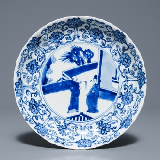 Een Chinees blauwwit gelobd bord met figuren op een terras, Kangxi merk en periode
