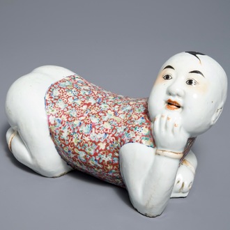 Un repose-tête en porcelaine de Chine famille rose en forme d'un garçon, République, début du 20ème