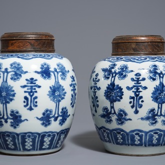 Une paire de pots en porcelaine de Chine bleu et blanc aux couvercles en bois, 18/19ème