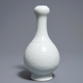 Un vase en porcelaine blanc de Chine à décor incisé de dragons, marque de Qianlong, 19/20ème