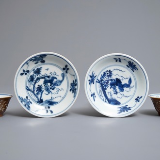 Une paire de tasses et soucoupes en porcelaine de Chine bleu et blanc à décor gravé sur fond brun capucin, Kangxi