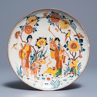 Een polychroom Delfts chinoiserie bord met figuren bij een tijger, 18e eeuw