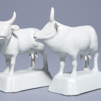 A pair of white Dutch Delft models of cows on bases, 18th C.