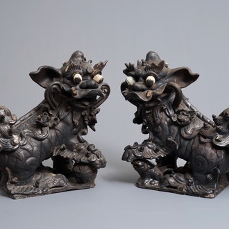 Deux tuiles faitières en forme de lions bouddhiques en grès émaillé noir, 19ème