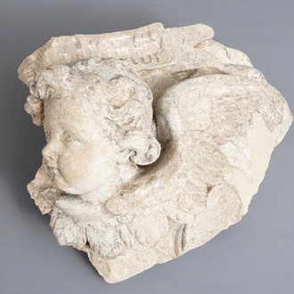 A carved stone wall fragment of a cherub's head with wing, 17/18th C.