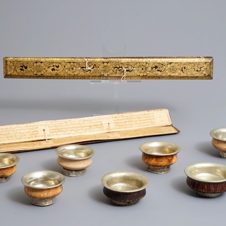 Seven burl wood and silver teabowls and two gilt wood encased Buddhist scriptures, Tibet, 19/20th C.