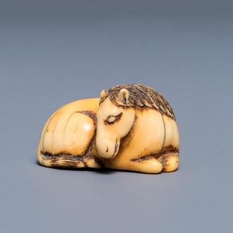 Een Japanse ivoren netsuke in de vorm van een liggend paard, Edo, 18/19e eeuw